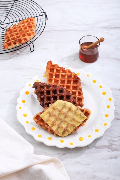 Roffle croisant wafel met diverse topping, kaas, chocolade, suiker en kaneel. croffle is viral street food uit korea.