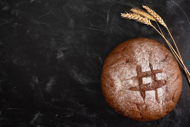 Roggebrood en tarwe op een donkere tafelblad weergave