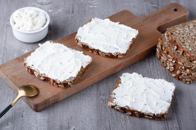 Roggebrood met roomkaas op grijze tafel