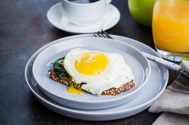 Roggebrood toast met gebakken spinazie en ei. gezond ontbijt eten concept.