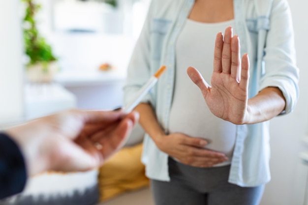 Roken en zwangerschap Zwanger meisje weigeren sigaret te gebaren Stop zwangere vrouw met buik weigert passief roken Het concept van de afwijzing van slechte gewoonten