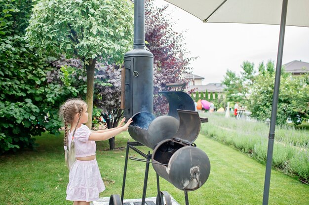 Rokersgrill in de achtertuin van het huis, familieterras, buiten bbq-feest op de achtergrond van de groene tuin in de open lucht