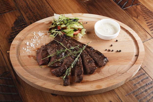 Roksteak met salade en saus Houten achtergrond