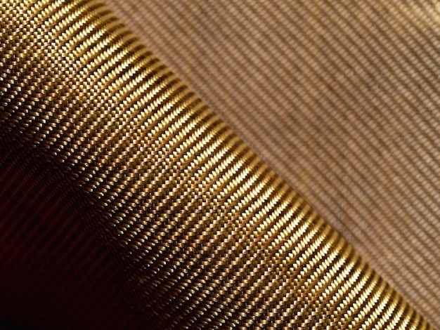 Rol kogelvrij materiaal aramide Glanzende aramide kevlar achtergrond Bronzen kevlar textuur en patroon