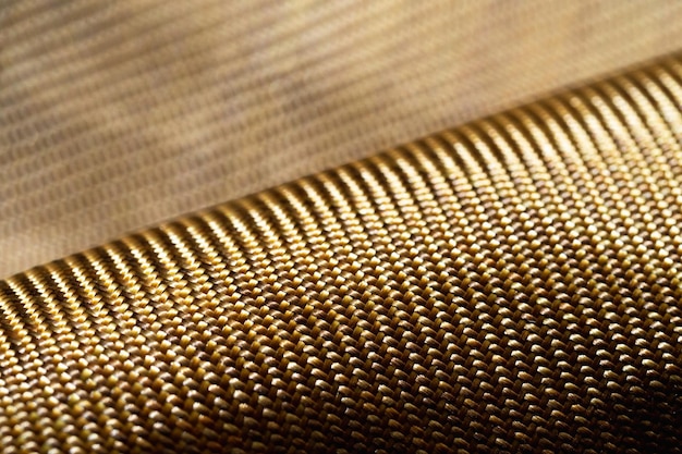 Rol kogelvrij materiaal aramide Glanzende aramide kevlar achtergrond Bronzen kevlar textuur en patroon