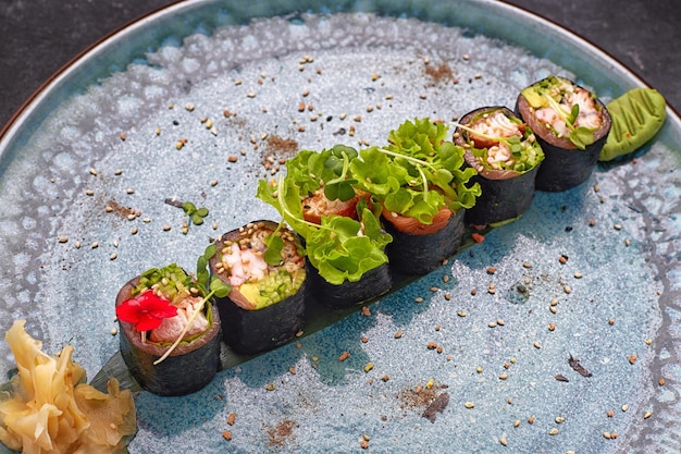 Rol met garnalen zalm en tonijn op een bord