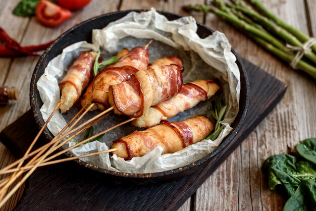 Rol met spek en kipgehakt op een stoofpotje met verse asperges en kruiden