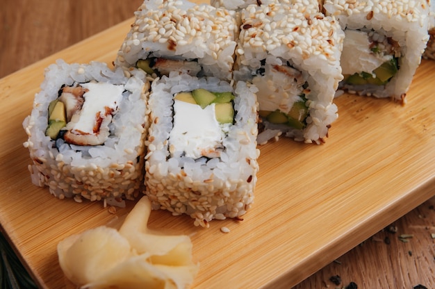 Rol sushi traditioneel met palingvis en avocado op een houten bord