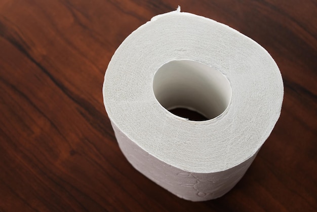 Rol wit toiletpapier op een houten ondergrond