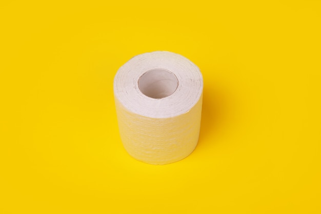 Rol wit toiletpapier op gele achtergrond