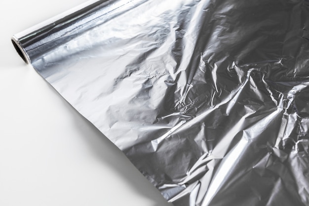 Foto rotolo di foglio di alluminio isolato su bianco