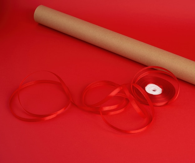 Roll of brown paper for packaging, a reel of red ribbon