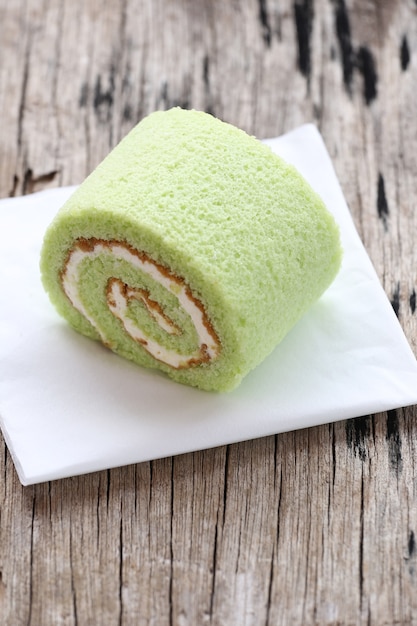 Roll cakes jam flavor pandan leaves on white paper.