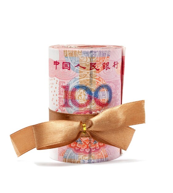 Photo roll of chinese yuan banknotes tied with gold ribbon isolated on white