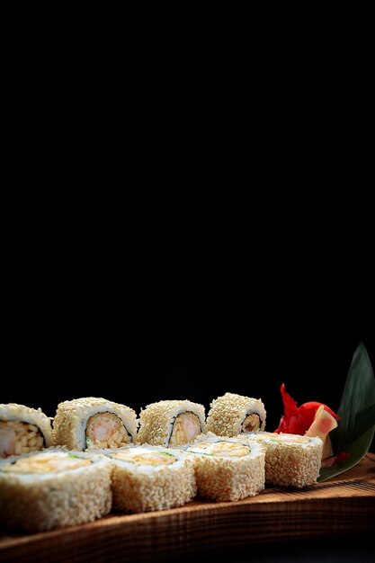 Roll Ebi Ringo with tiger shrimp cream cheese apple and tobiko on a wooden board on a dark background