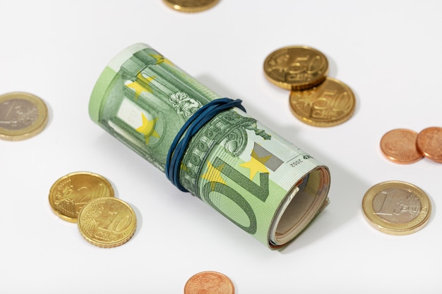 roll of euro bills with rubber band and coins isolated on white background. money concept