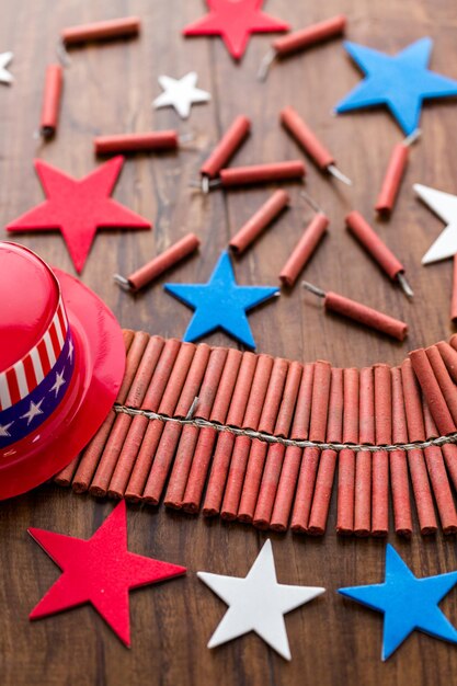 Roll of firecrackers with red, white and blue stars on wood table.