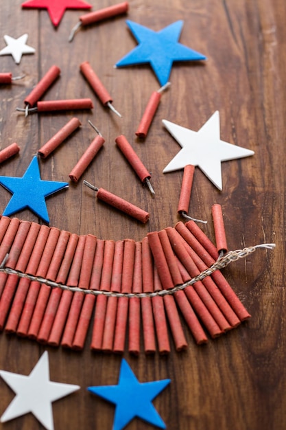 Roll of firecrackers with red, white and blue stars on wood table.