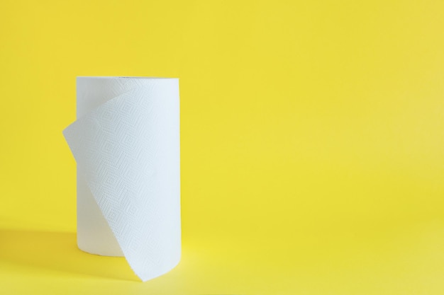 Roll of paper towel on yellow background