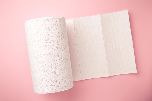 Roll paper towels on on pink background Top view