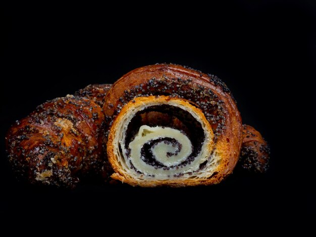 Photo roll pastry with poppy seed fresh buns on a black background