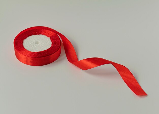 A roll of satin ribbon for decorating gifts on a white background Silk and satin ribbon