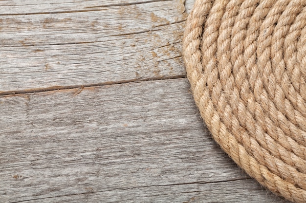 Photo roll of ship rope on wooden texture background