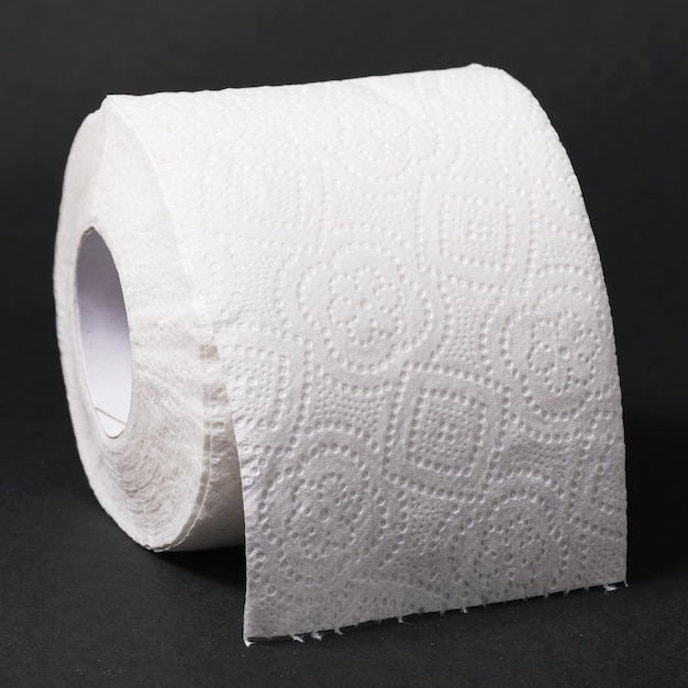 Roll of toilet paper on a dark background closeup