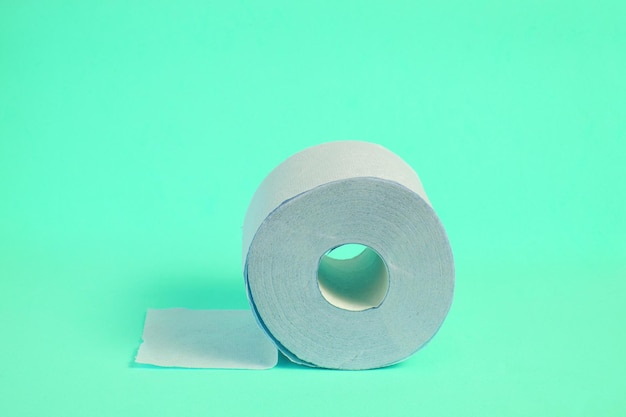 Roll of toilet paper on a turquoise background.