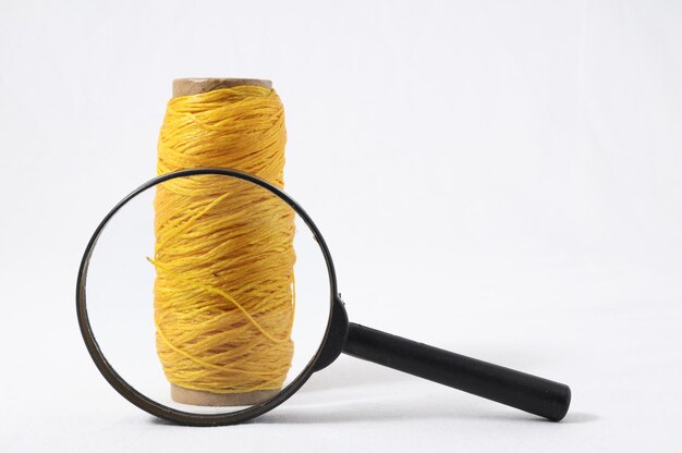 Roll of Twine and Loupe on a White Background