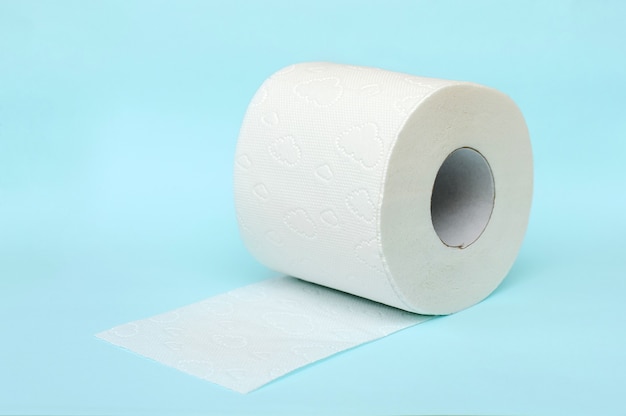 Roll of white toilet paper on blue background