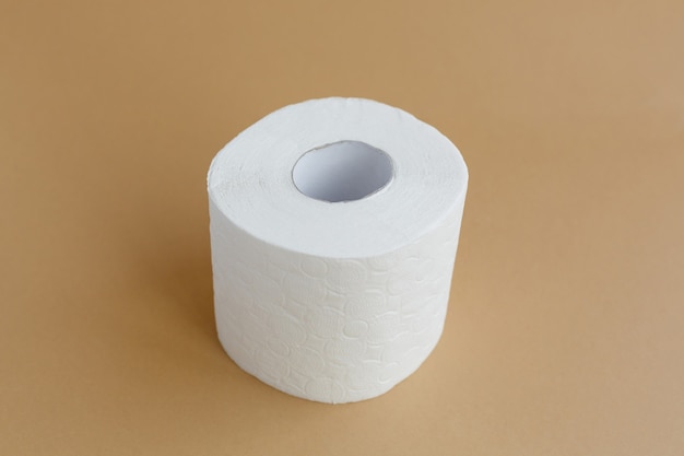 Roll of white toilet paper on a brown background