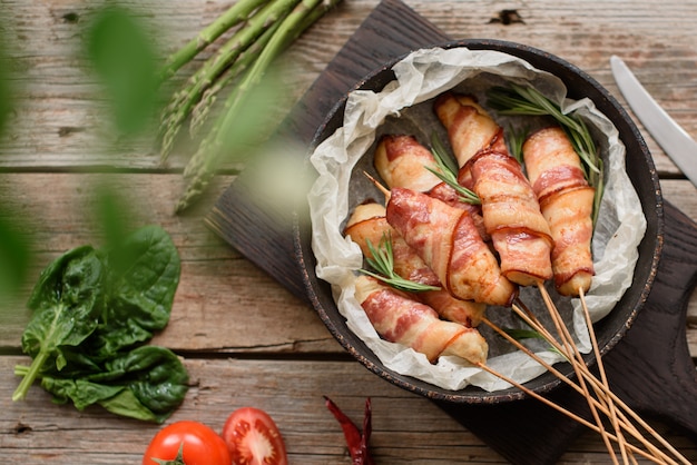 Roll with bacon and chicken mince on a stew with fresh asparagus and spices