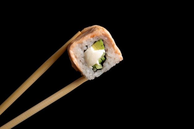 roll with fried salmon on a black background