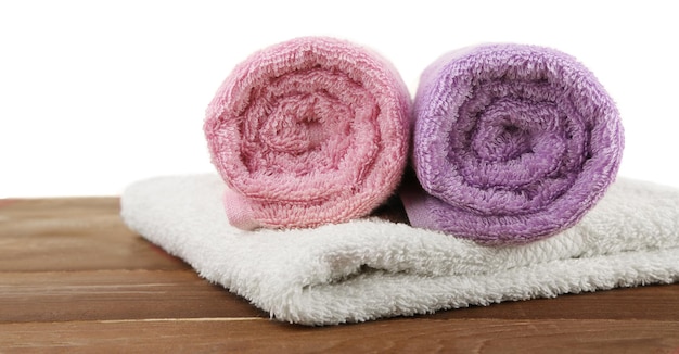 Rolled bath towels on wooden table closeup