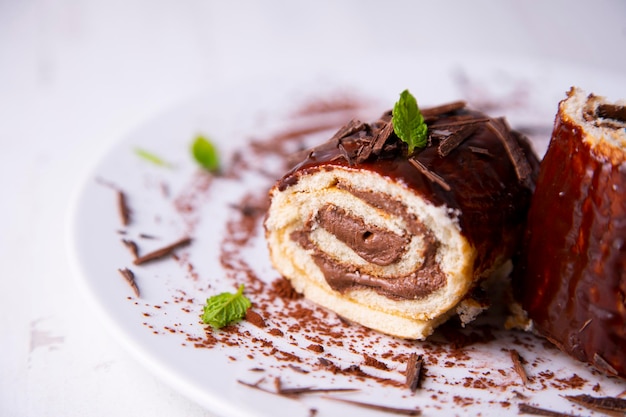 Foto torta al cioccolato arrotolata decorata come un ceppo di natale con cioccolato.