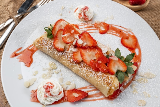 Rolled crepes or pancakes with fresh chopped strawberries