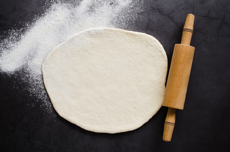 Photo rolled dough, baking flour and rolling pin 