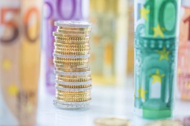 Rolled euro banknotes and coins towers stacked in other positions.