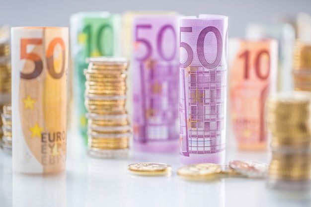 Photo rolled euro banknotes and coins towers stacked in other positions.