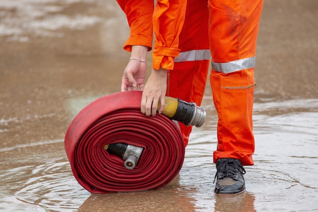 Photo rolled into a roll red fire hose, fire equipment extinguishers ready to use