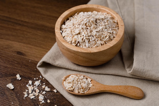 Fiocchi d'avena sani cereali per la colazione farina d'avena in una ciotola su un tavolo di legno