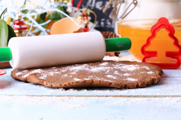 Rolled out dough for gingerbread Christmas homemade cakes on a light wooden background selective soft focus rustic style