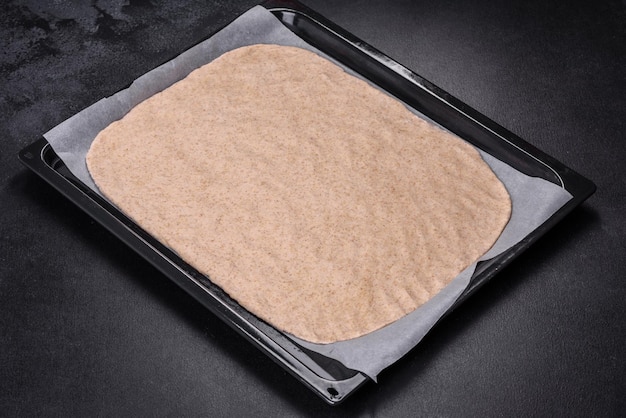 Rolled out prepared raw dough on parchment and baking sheet