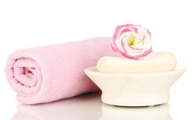 Rolled pink towel soap bar and beautiful flower isolated on white