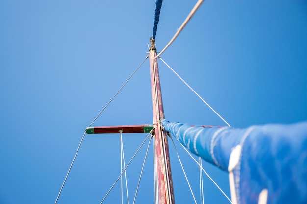 The rolled sail is attached to a tall mast Preparation for departure to the open sea