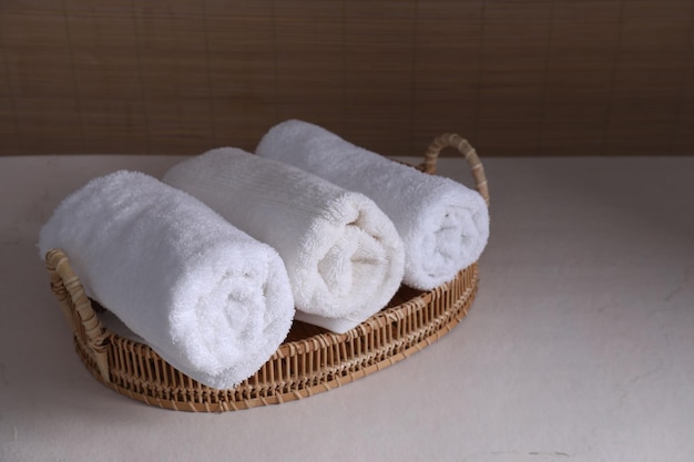 Rolled terry towels on white table indoors space for text