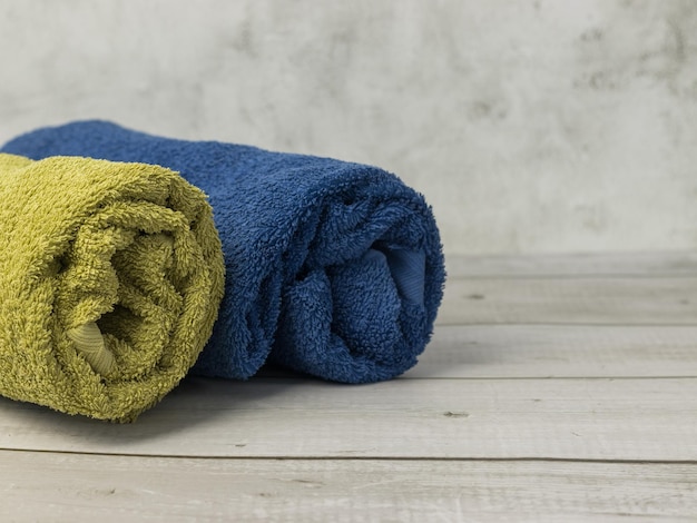 Rolled towels on wooden table in bathroom blue and green