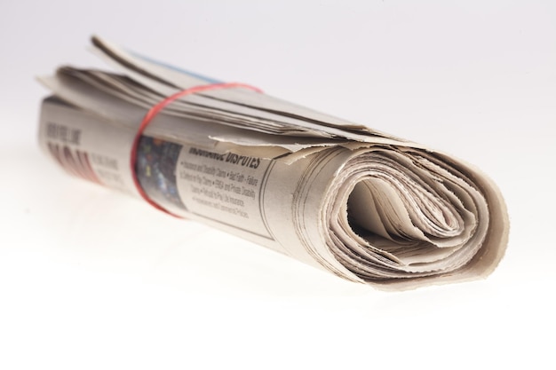 Photo rolled up newspapers close up on light background