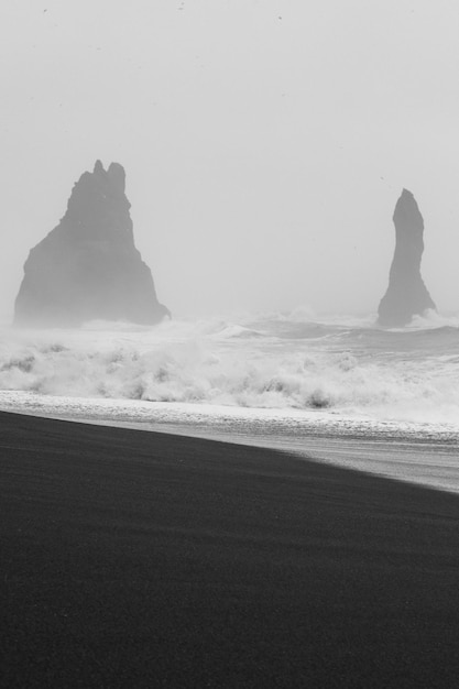 Rollende golven op zwarte strand zwart-wit landschapsfoto